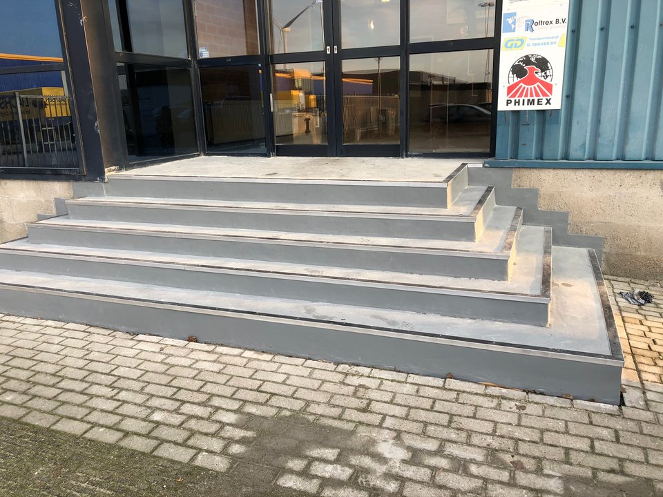 Gerenoveerde entreetrap van een bedrijfspand met antislipneuzen