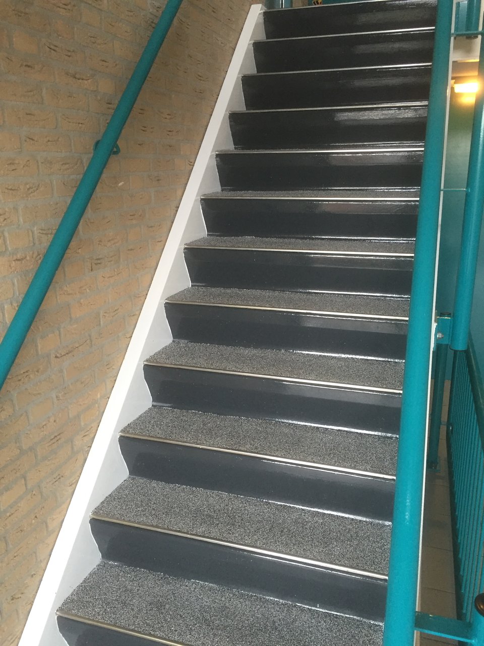 Dezelfde trap na renovatie met antislipcoating en witte trapneuzen